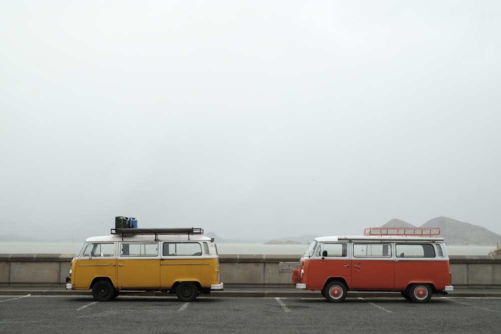 a couple of vans parked next to each other in a parking lot