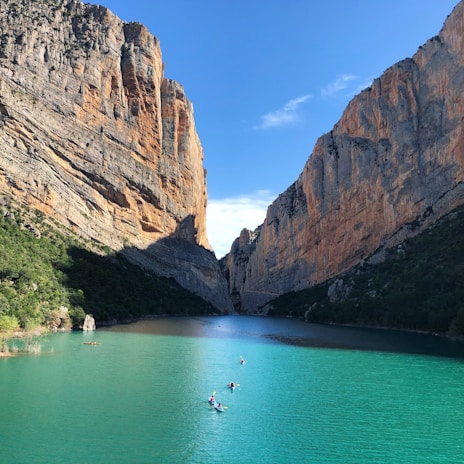 A scenic kayak trip down a crystal-clear river surrounded by towering cliffs.
