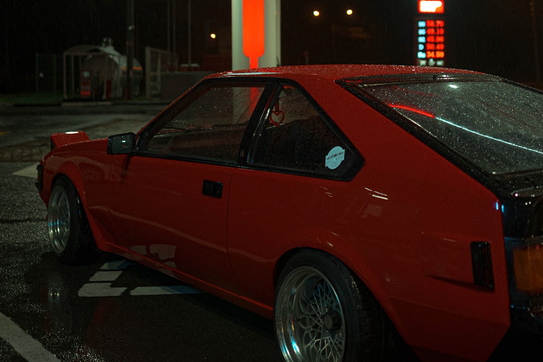 red coupe parked in front of building