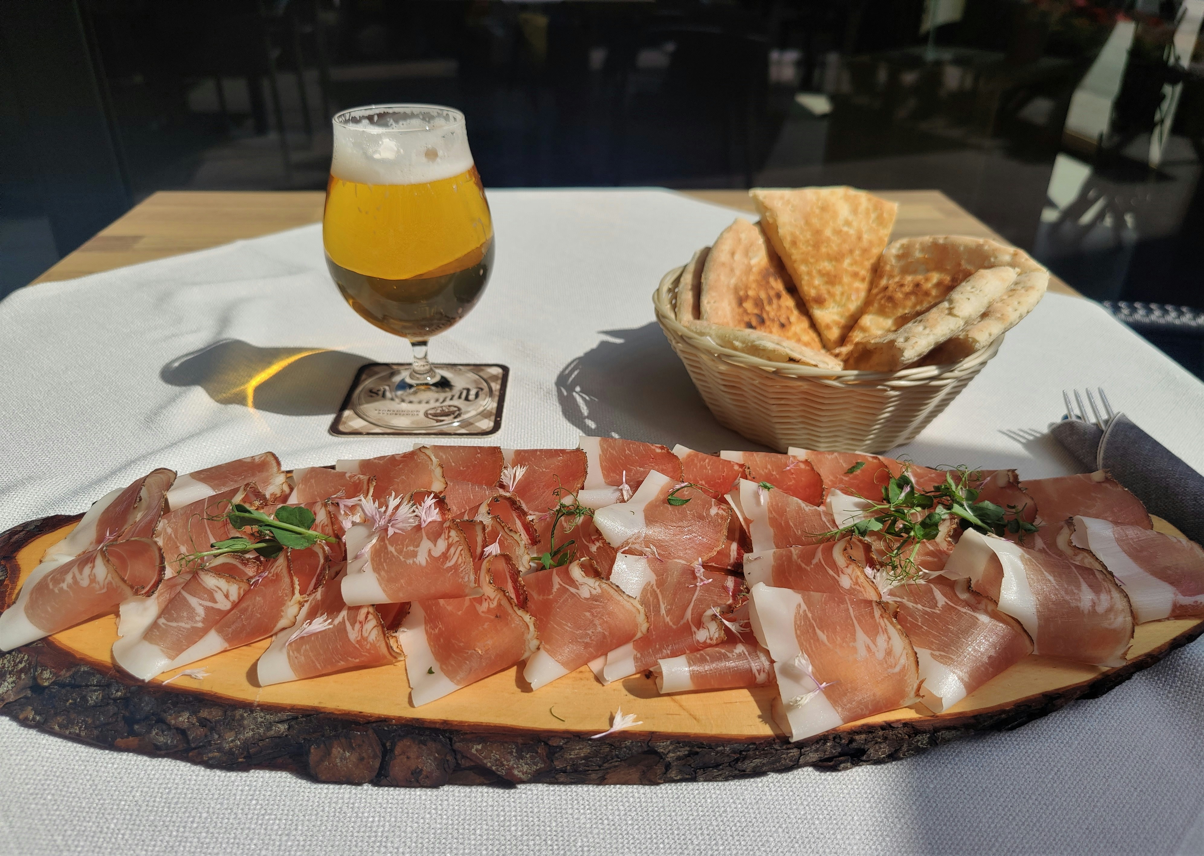 un plato de jam&oacute;n, queso y galletas saladas en una mesa