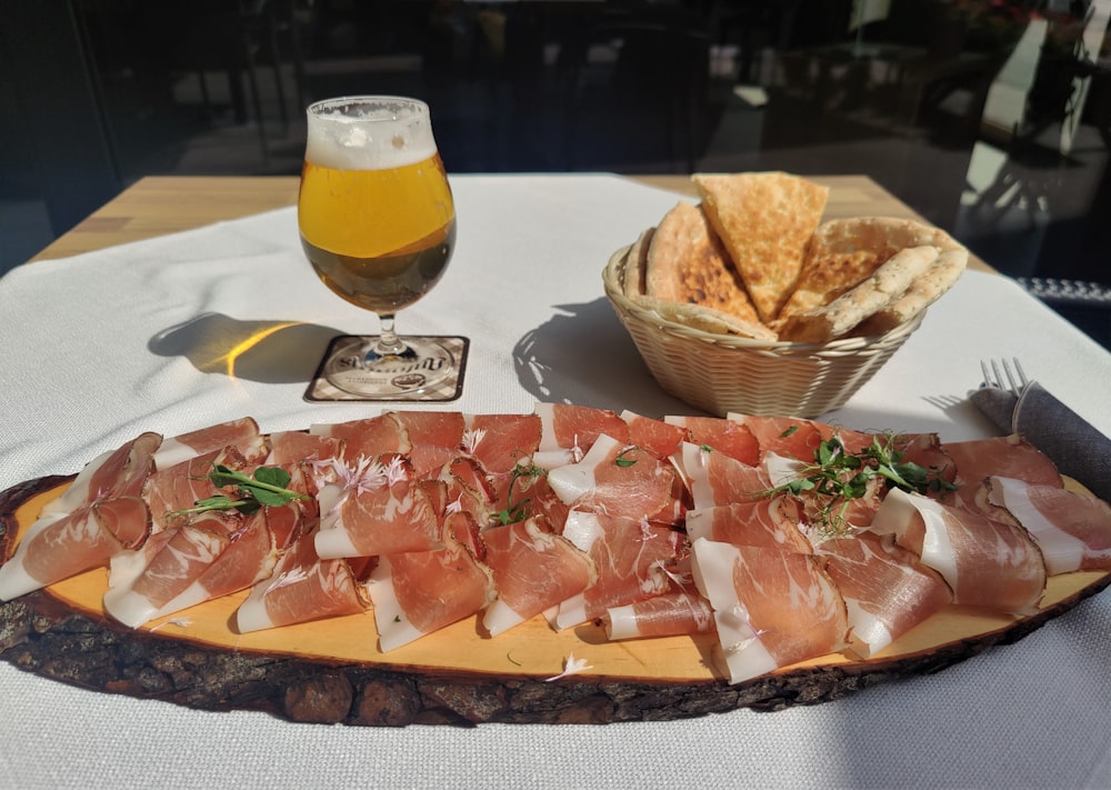 un plato de jamón, queso y galletas saladas en una mesa