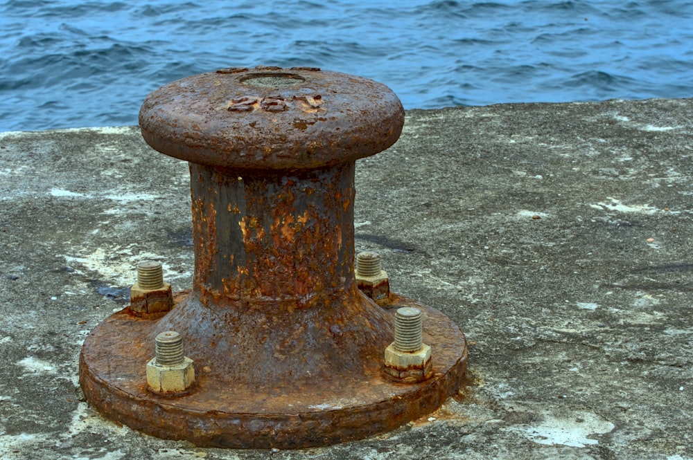 a rusted fire hydrant sitting on the side of a road