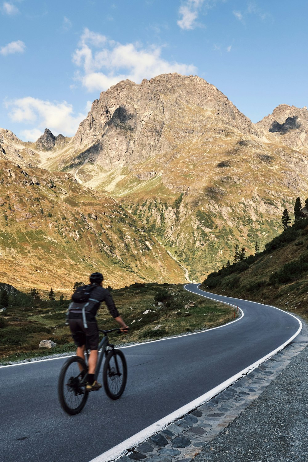 Ein Mann fährt mit dem Fahrrad eine kurvige Straße hinunter