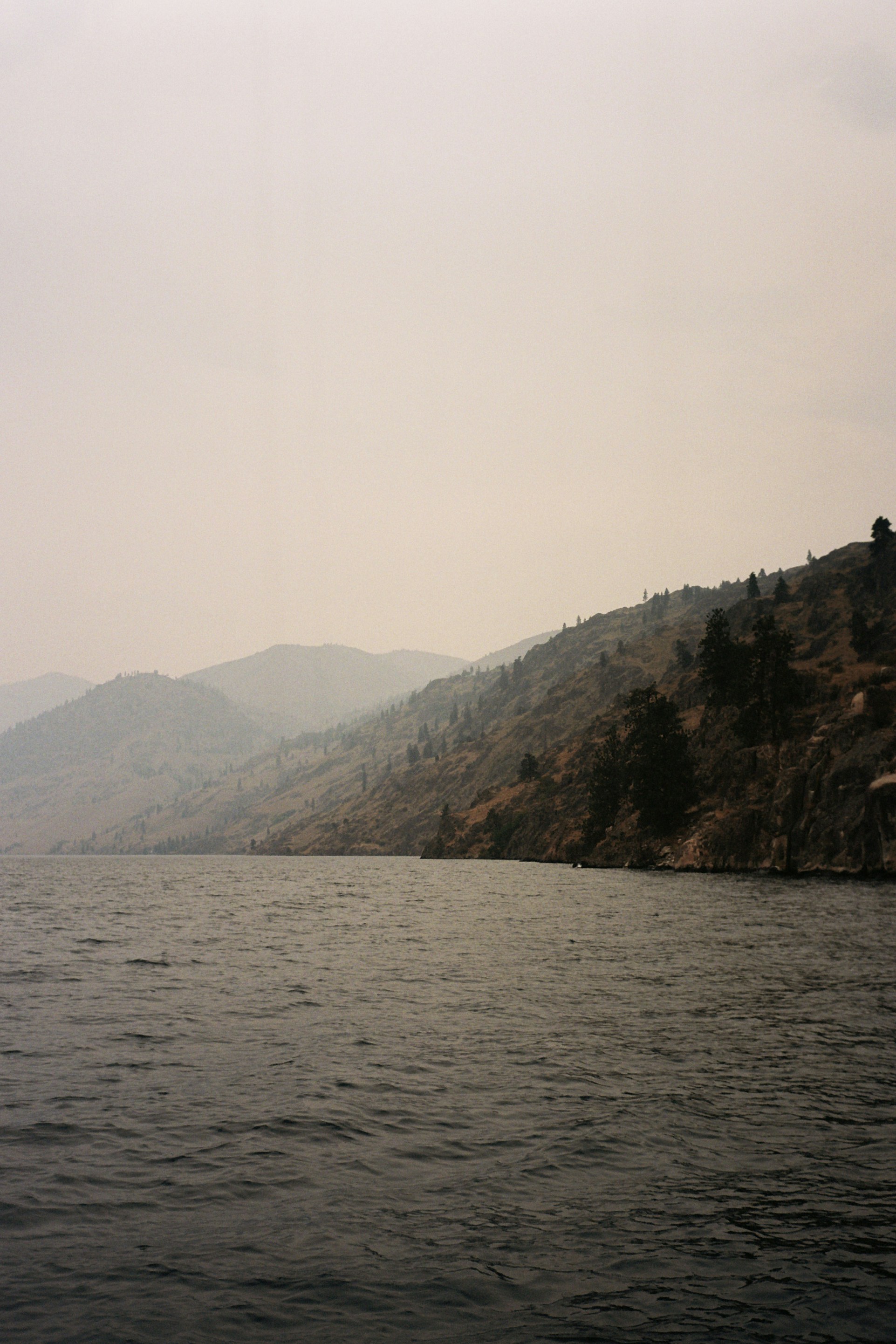 body of water near mountain during daytime