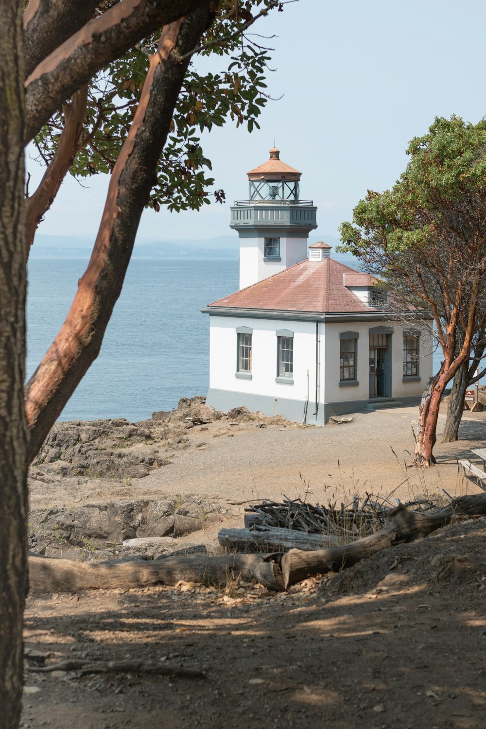 a light house sitting on top of a hill next to the ocean