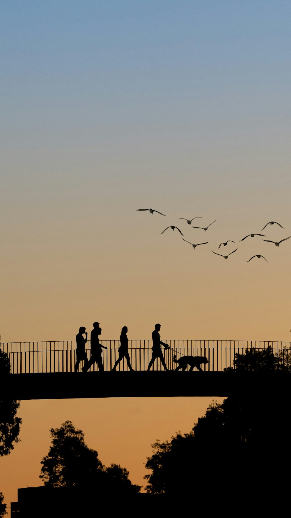 a group of people walking across a bridge