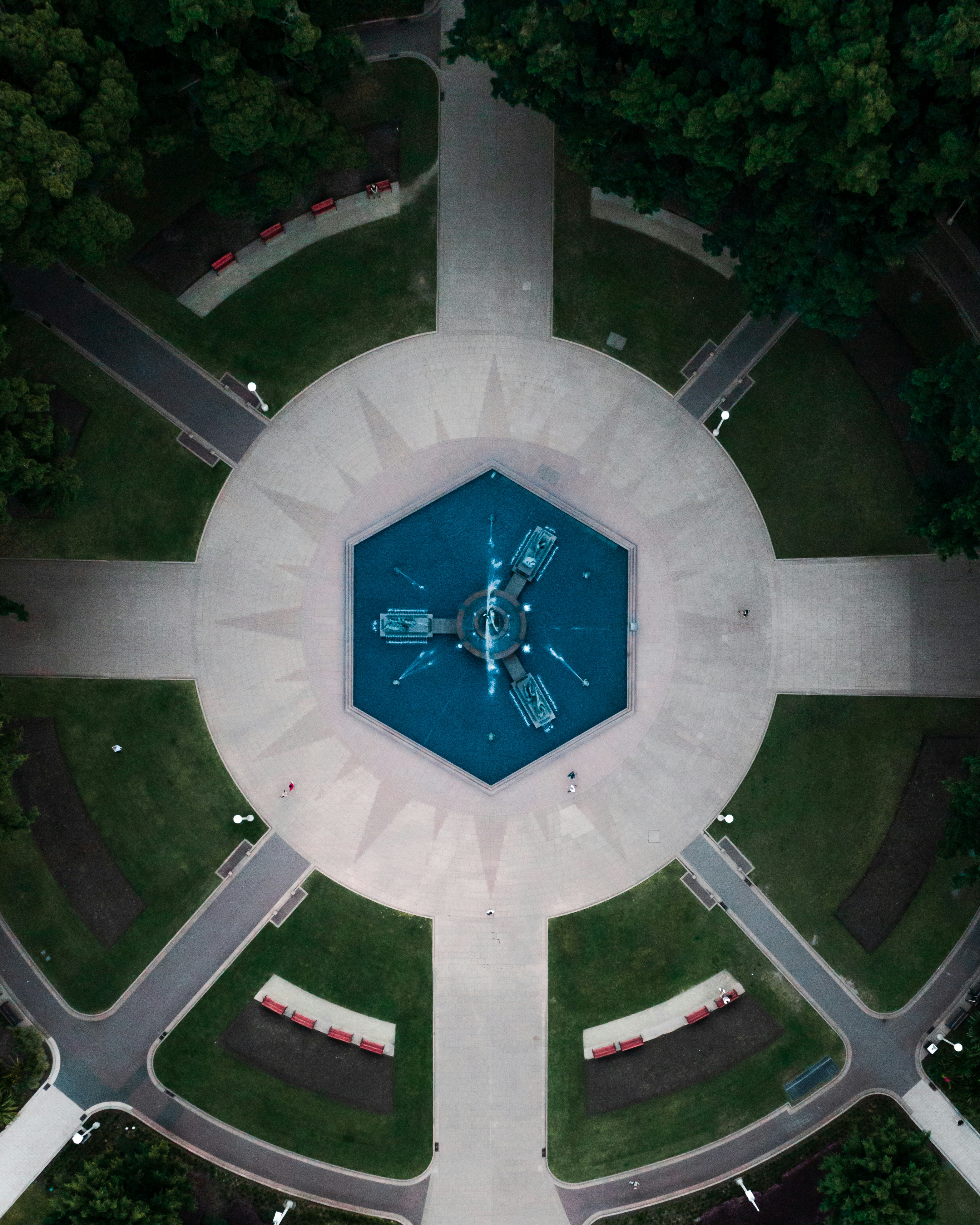 an aerial view of a clock in the middle of a park