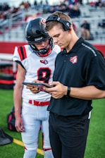 man in black and red nike jersey shirt holding black and red game controller