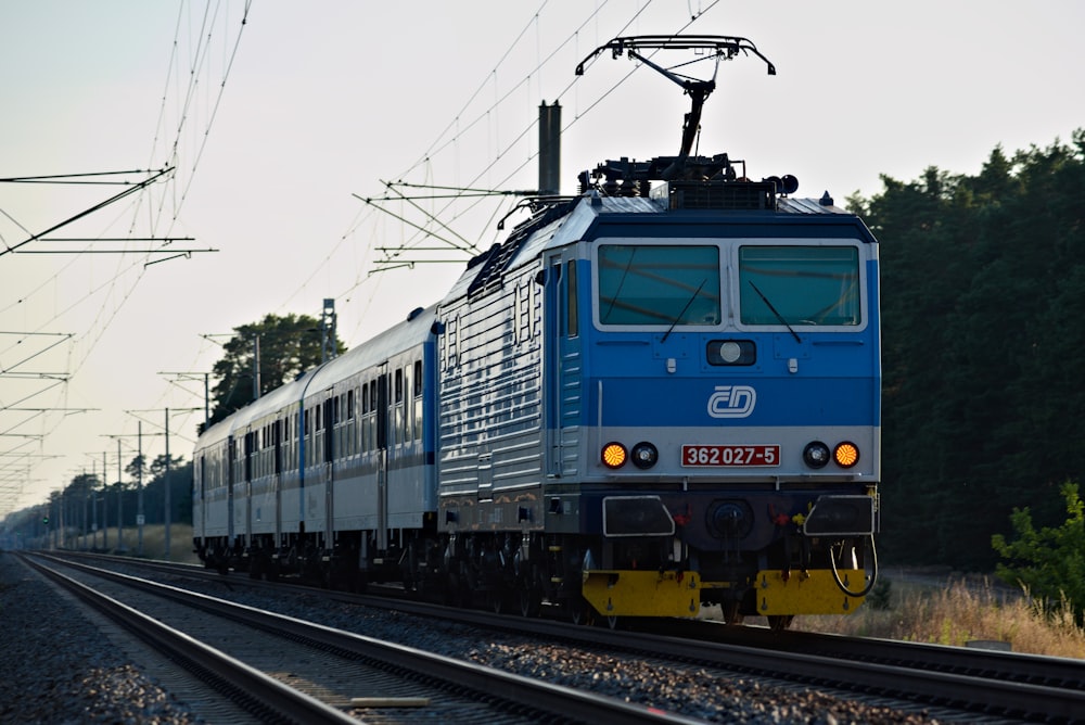 blue and gray train on rail tracks during daytime