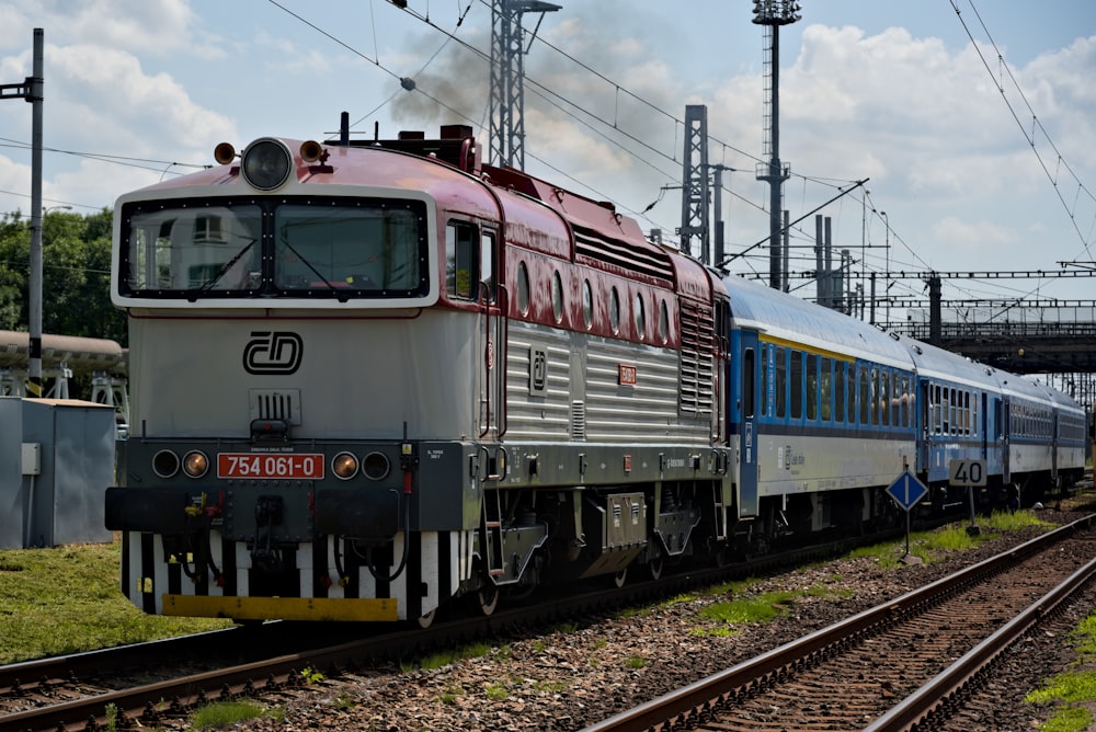 red and blue train on rail tracks during daytime