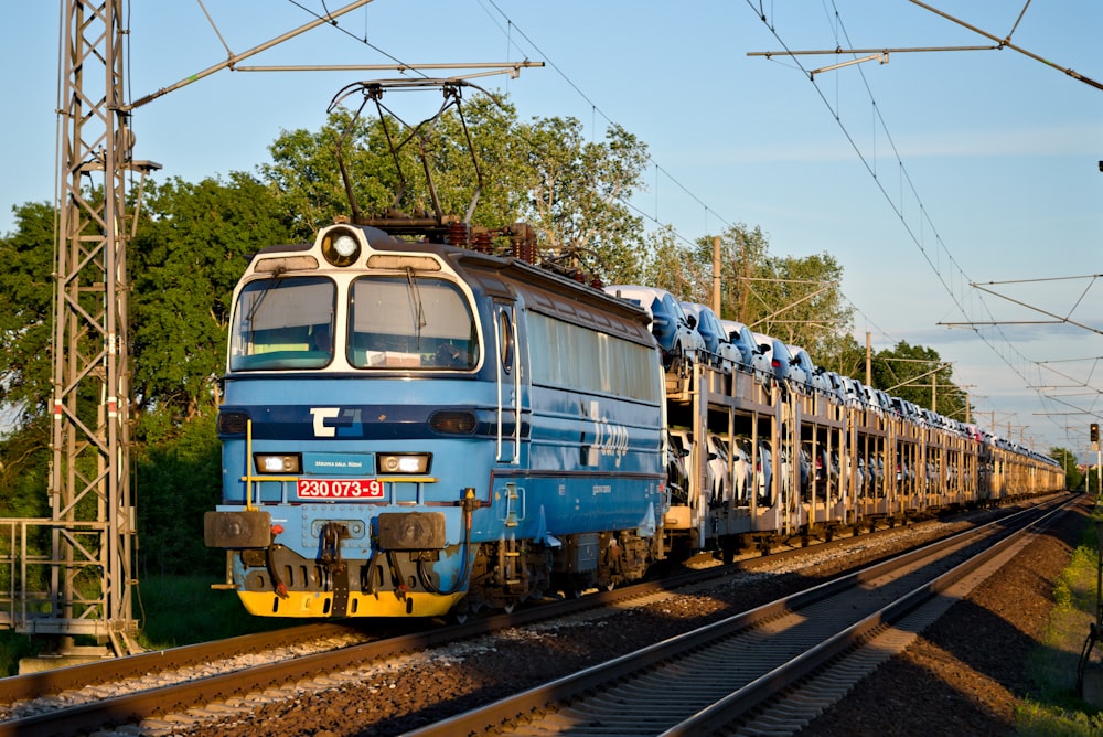 blue and brown train on rail tracks during daytime