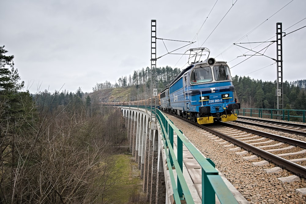blue and yellow train on rail tracks