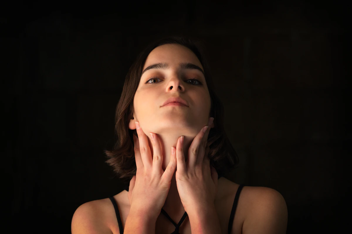 Portrait of a woman with her jawline and chin visible in soft natural light, illustrating a facial profile reviewed after chin filler treatment