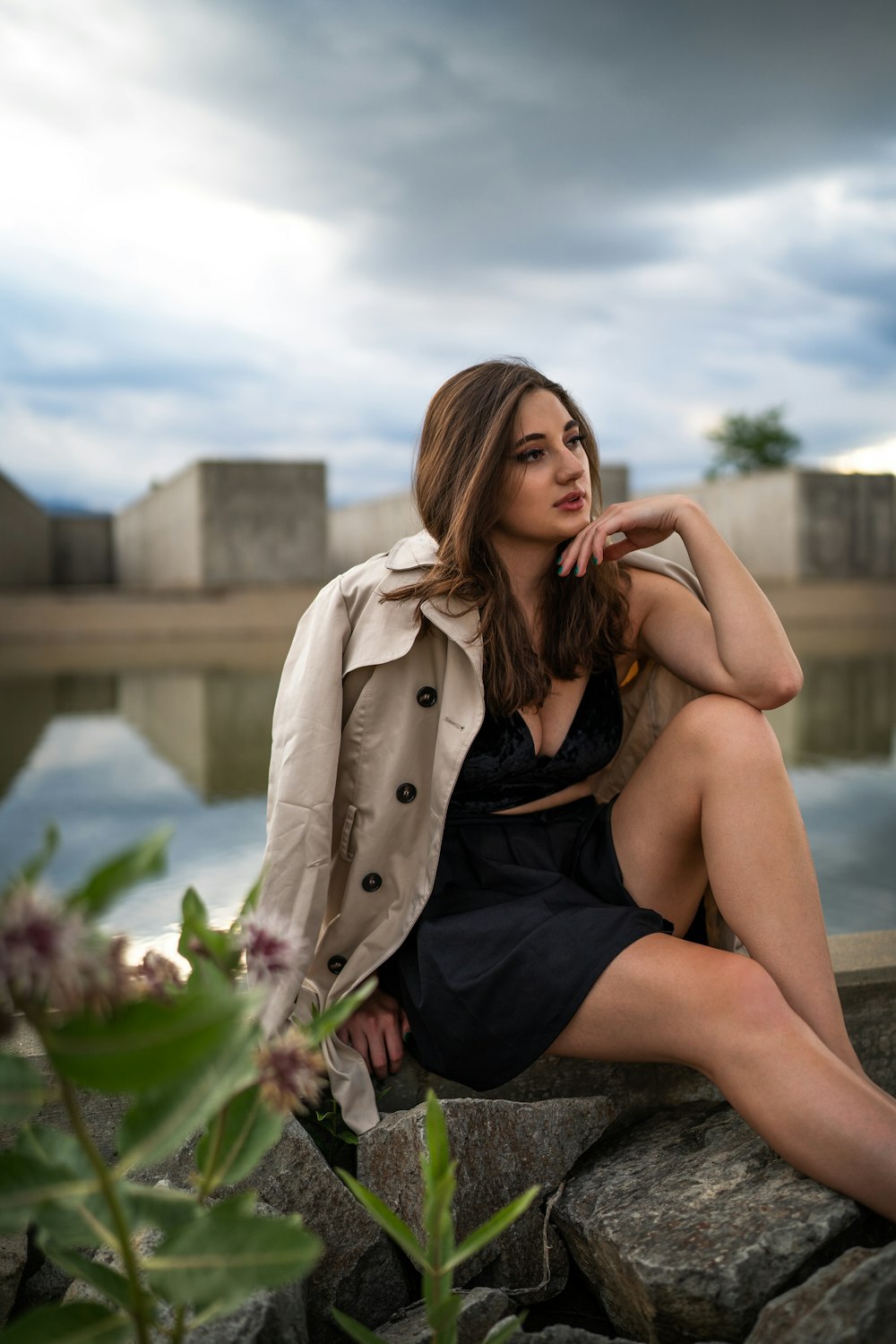 woman in black dress sitting on concrete bench during daytime