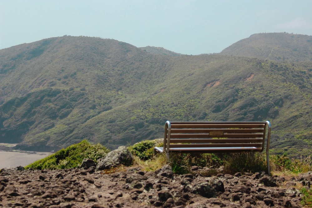 a wooden bench sitting on top of a lush green hillside