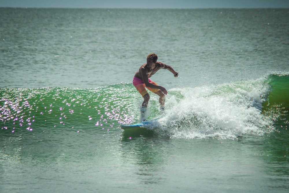 a woman riding a wave on top of a surfboard