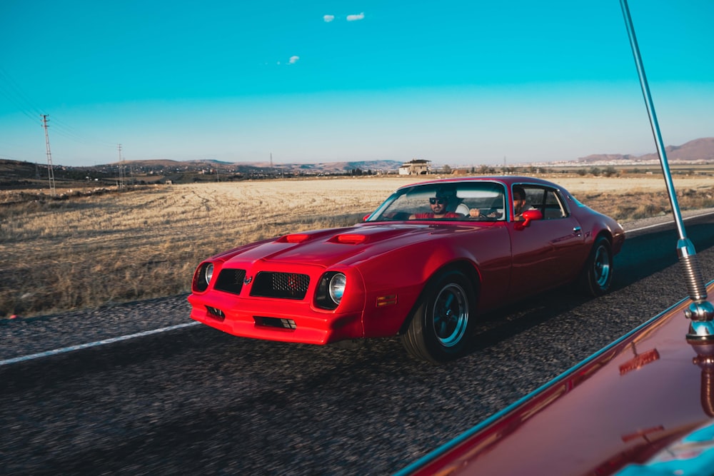 red chevrolet camaro on road during daytime