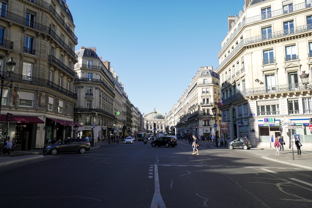 cars on road between high rise buildings during daytime