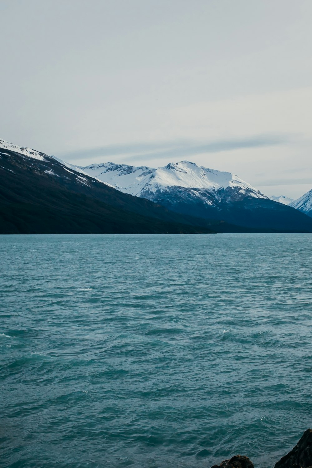 a large body of water with mountains in the background