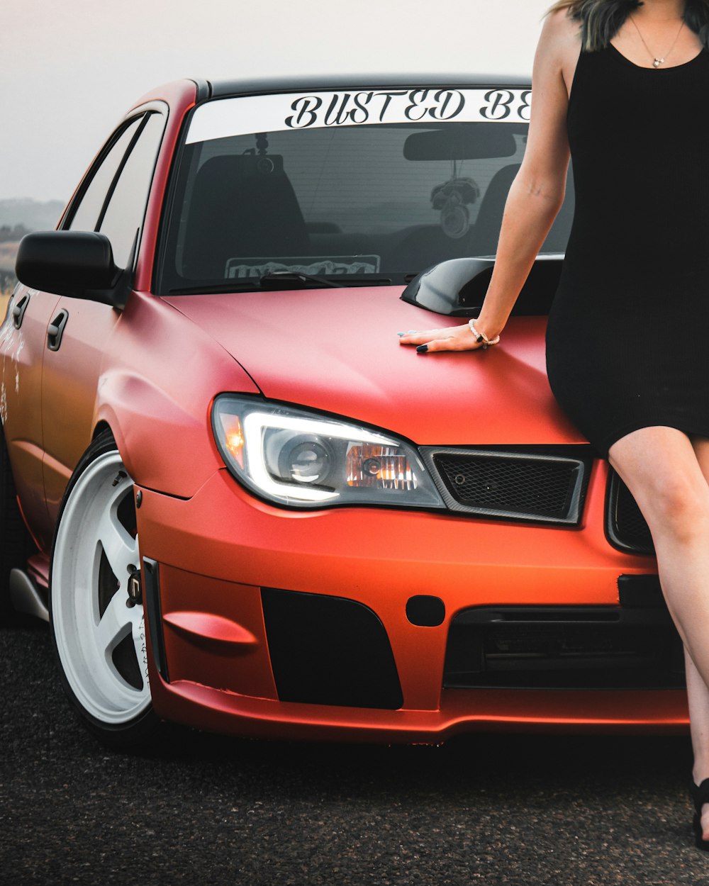 a woman sitting on the hood of a car