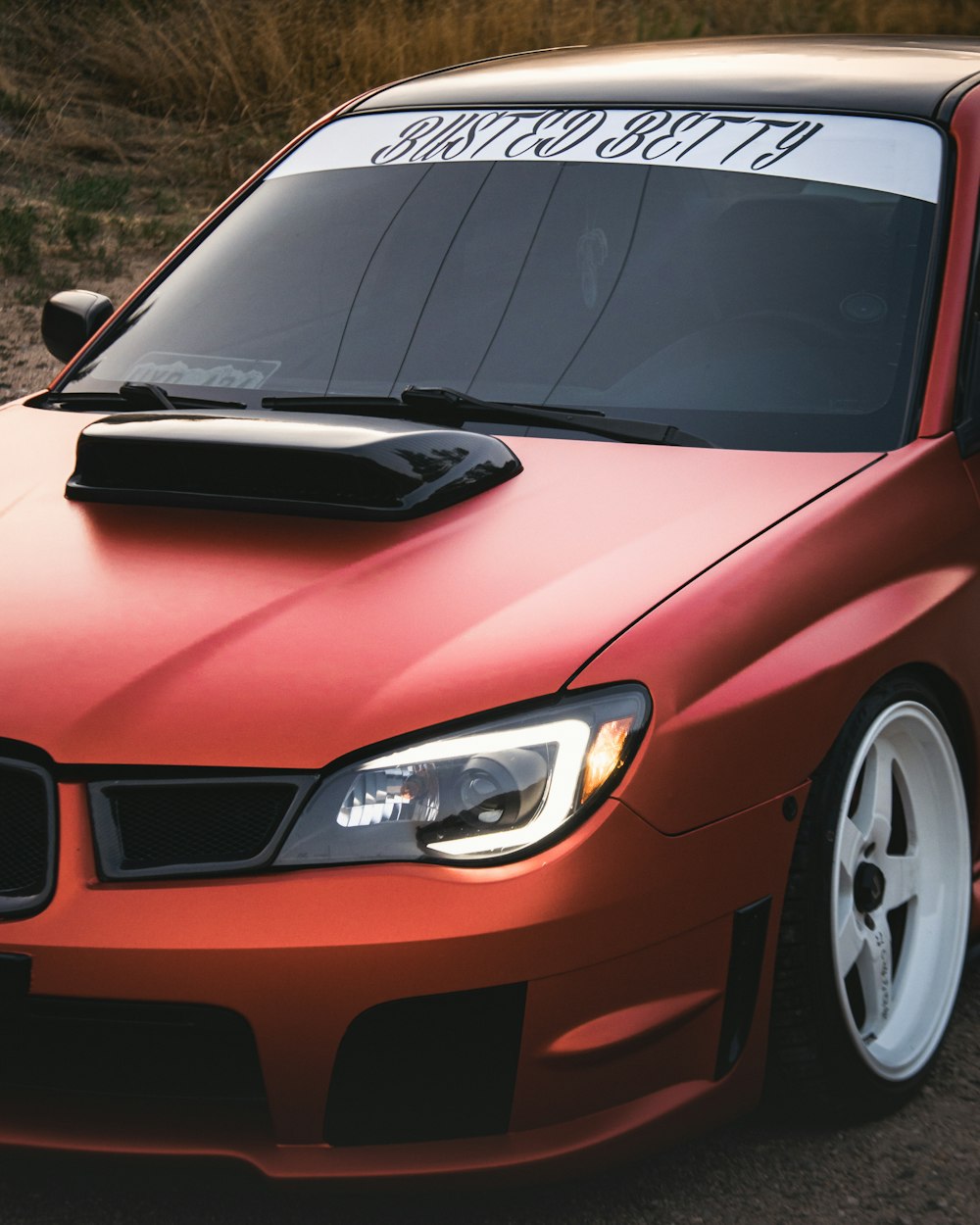 a red car with a sticker on the hood