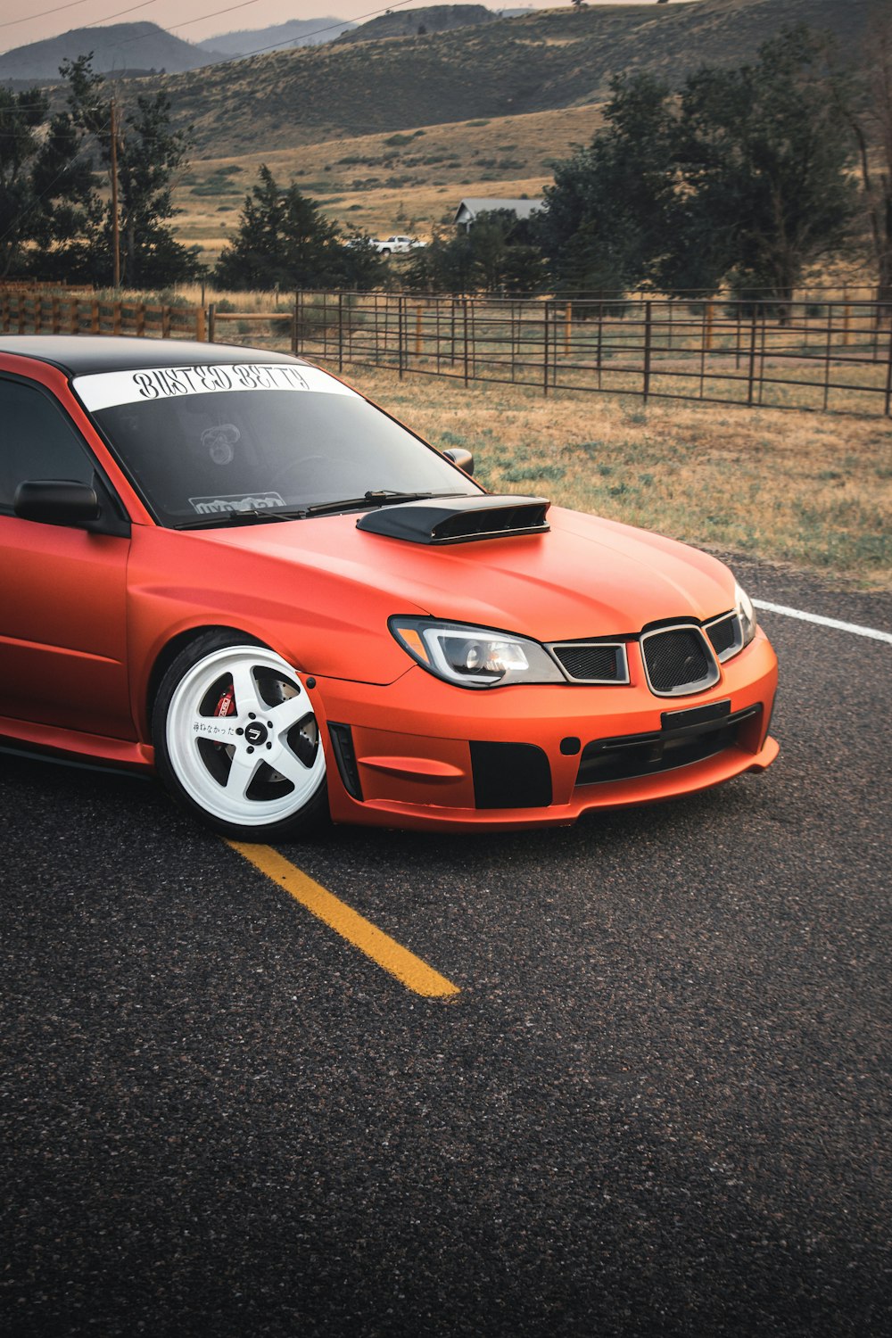 an orange car parked on the side of the road