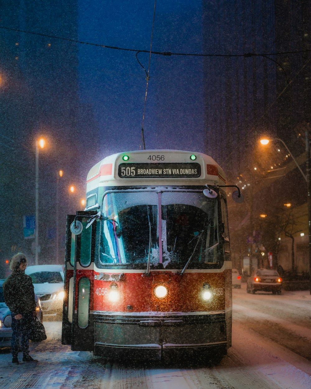 夜間の道路を走る赤と白のバス