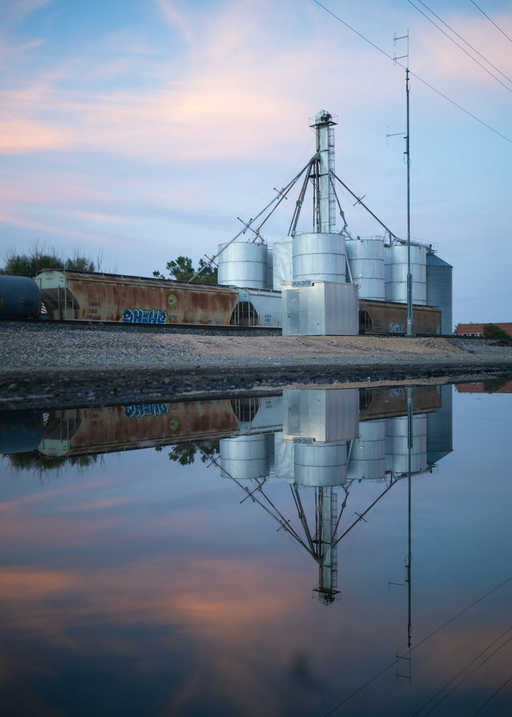 a large metal silo sitting next to a body of water