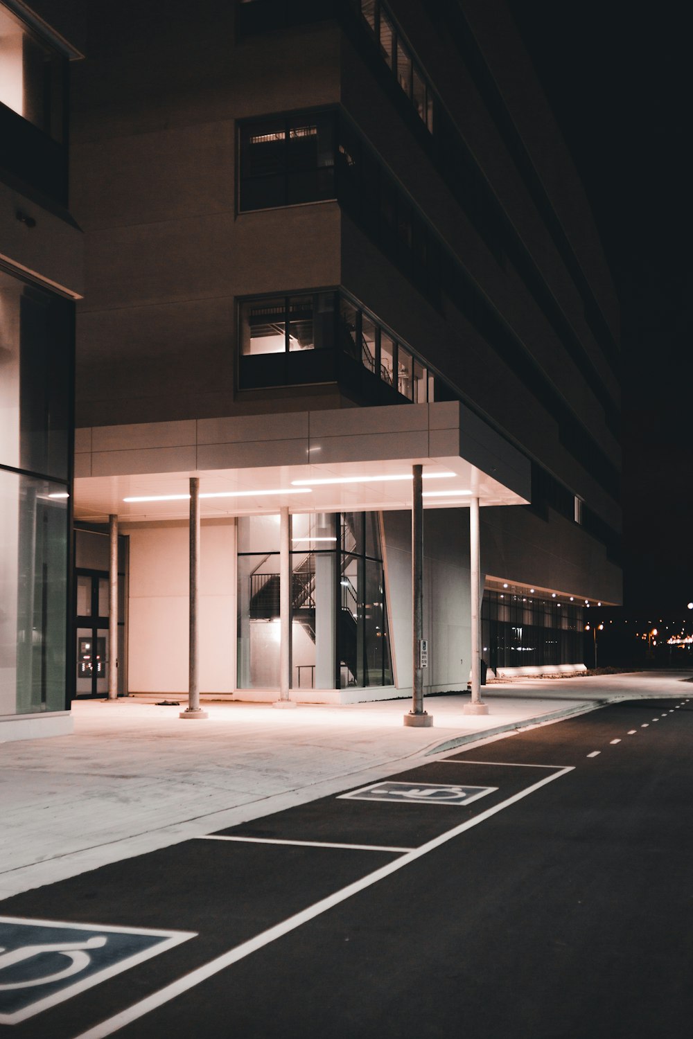 an empty parking lot in front of a building at night