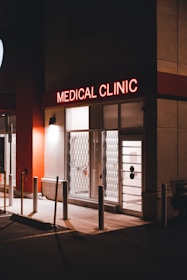 a medical clinic at night with a neon sign