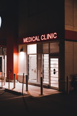 a medical clinic at night with a neon sign