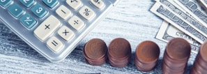 a calculator, pen, and money on a table