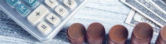 a calculator, pen, and money on a table