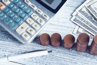 a calculator, pen, and money on a table