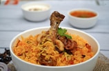 a white bowl filled with rice and meat