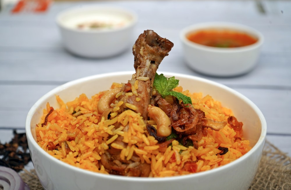 a white bowl filled with rice and meat