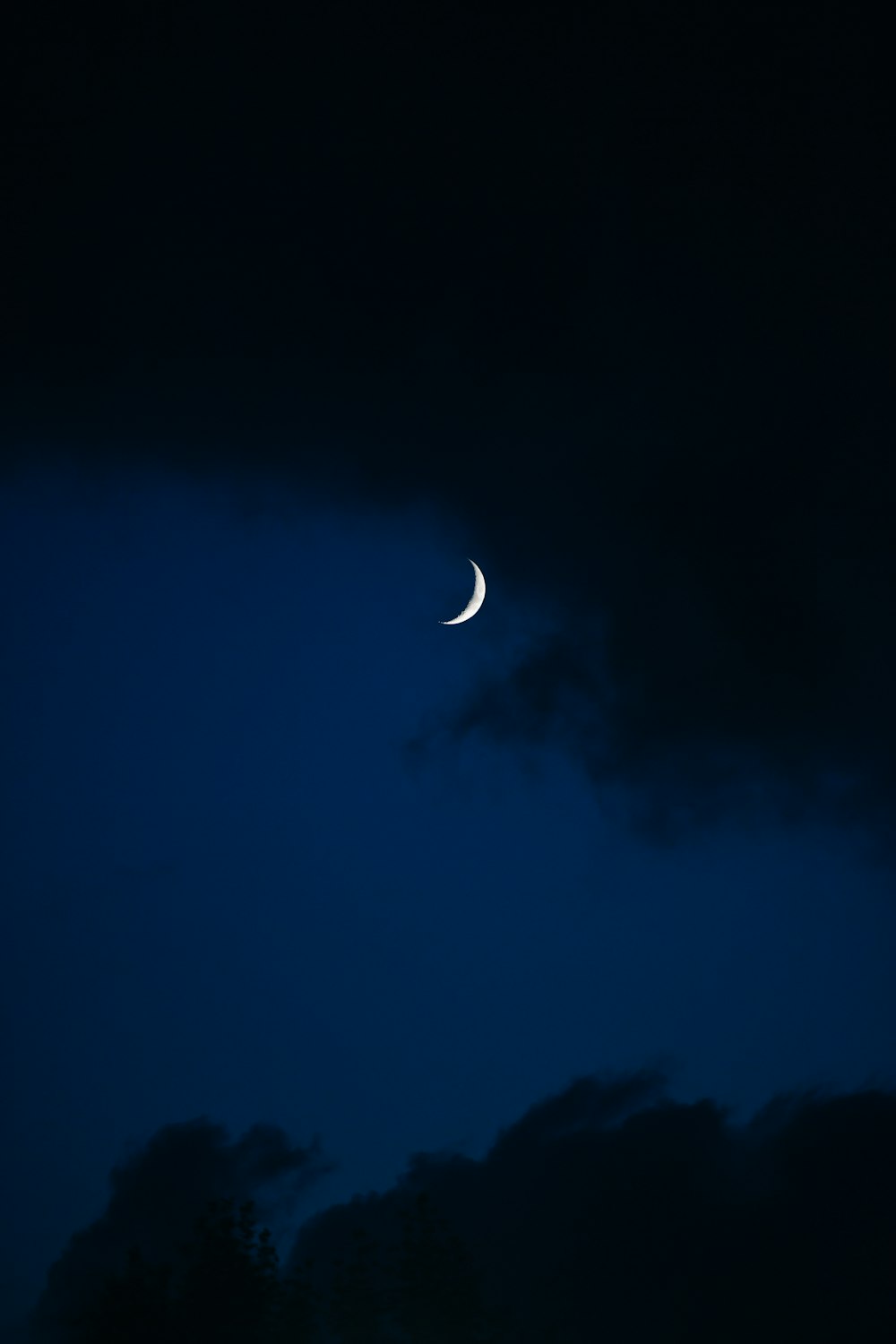 the moon is seen through the dark clouds