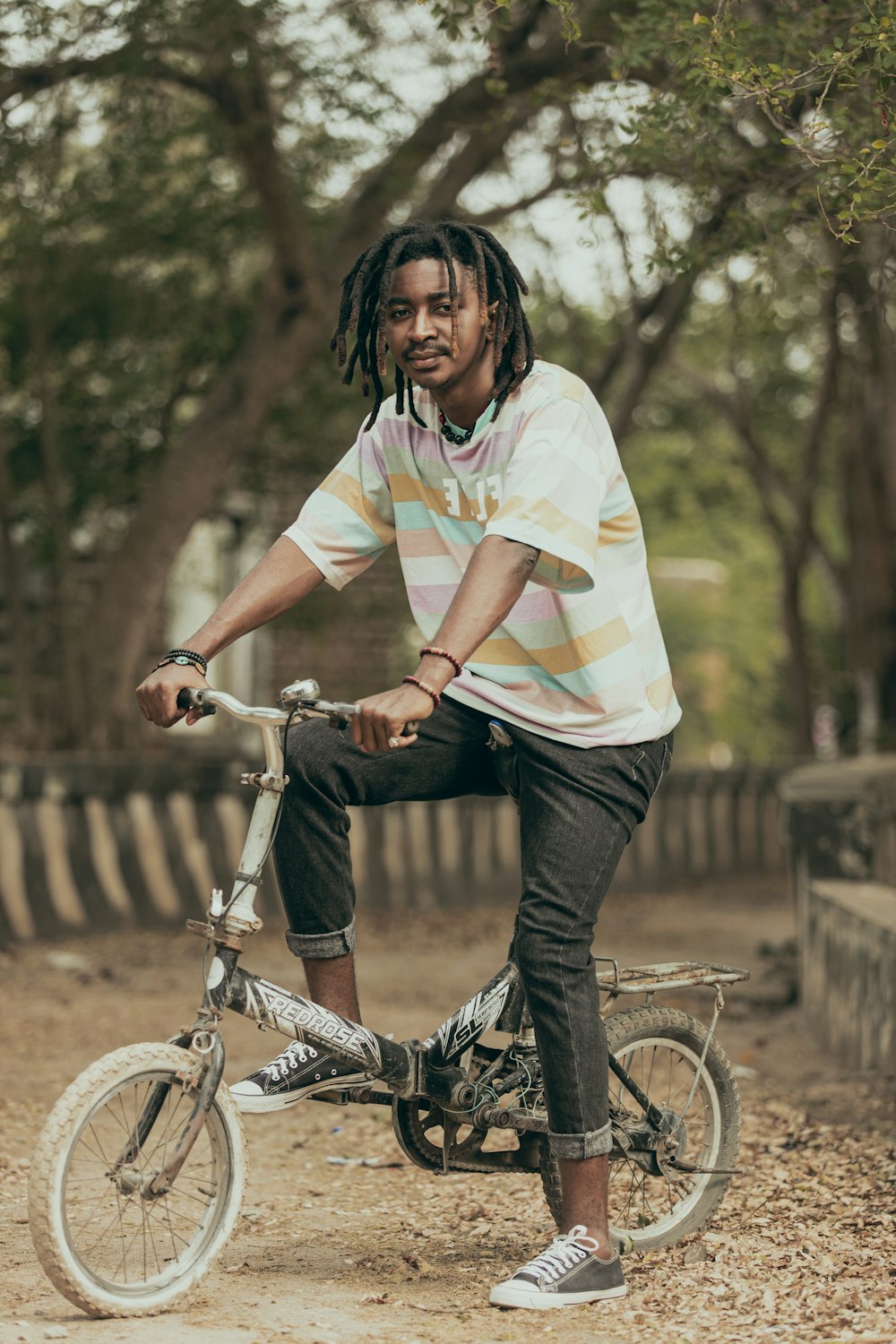 woman in white yellow and green stripe shirt riding on bicycle