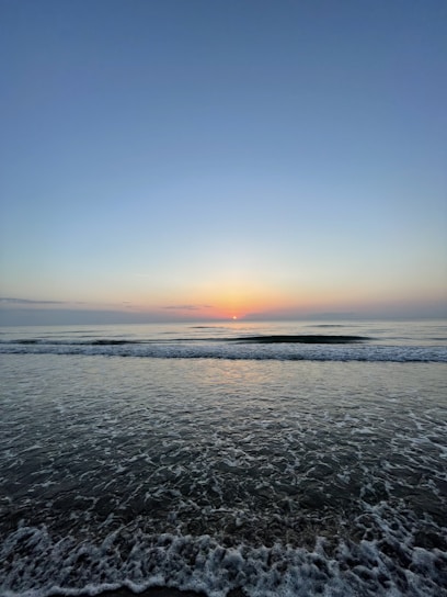 Sunrise view from the Sea View Suite balcony overlooking calm Arabian Sea waters.