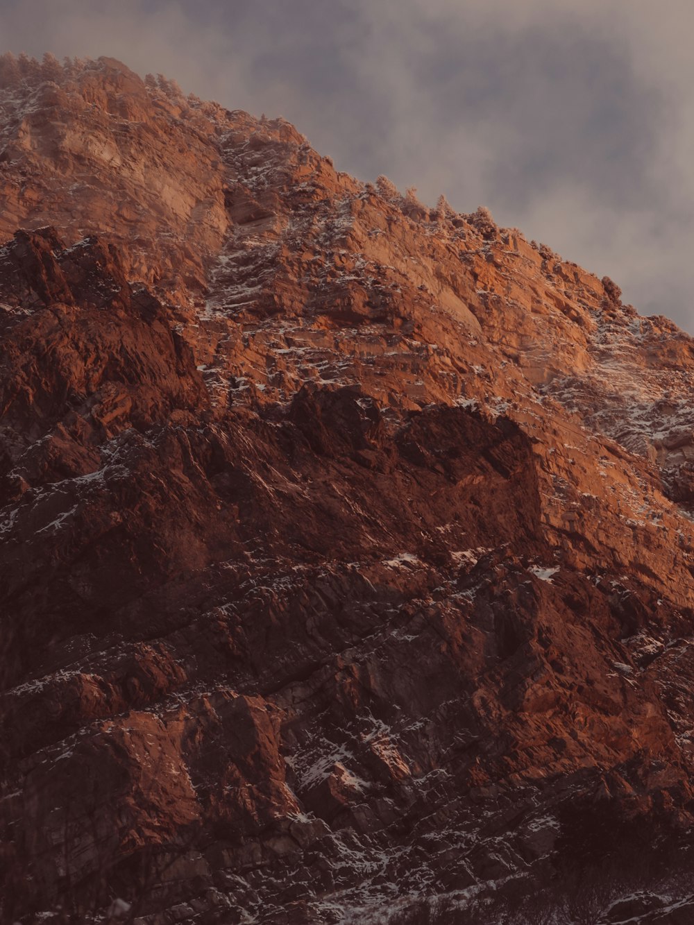 brown rocky mountain under cloudy sky during daytime