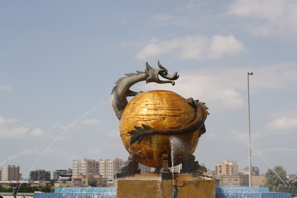 a statue of a fish on top of a golden ball