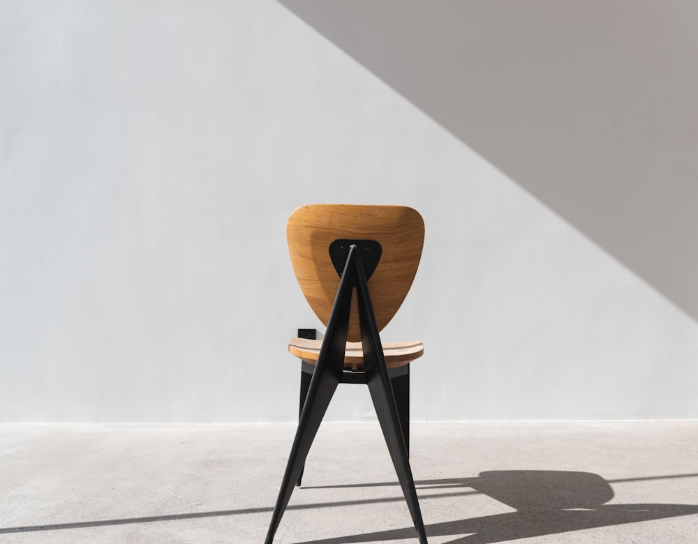 a chair with a wooden seat and black legs