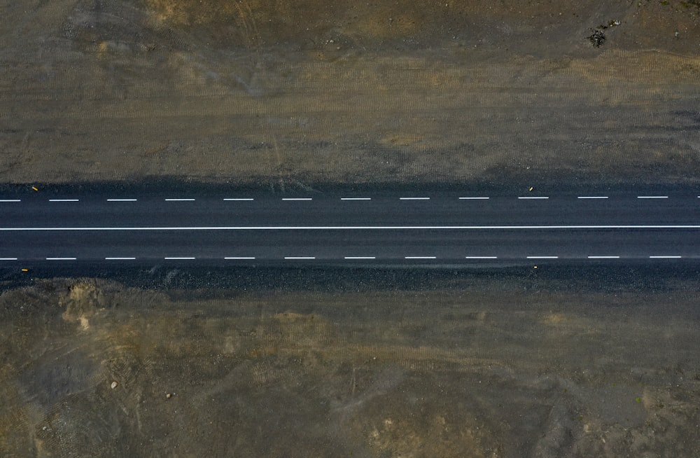 an aerial view of an empty road in the middle of nowhere