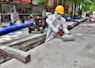 a man wearing a protective suit and a hard hat working on a street
