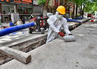 a man wearing a protective suit and a hard hat working on a street
