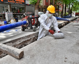 a man wearing a protective suit and a hard hat working on a street