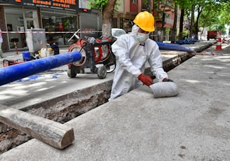 a man wearing a protective suit and a hard hat working on a street