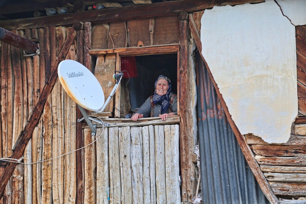 a woman looking out of a window of a shack