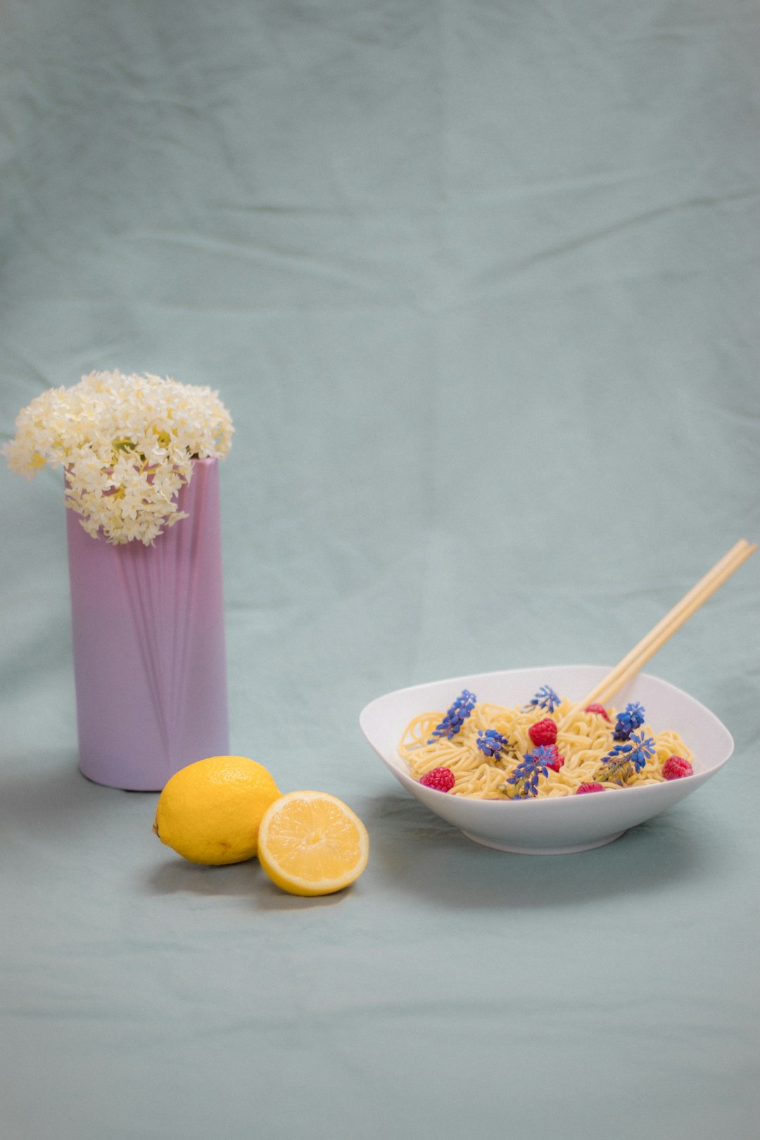 white and purple floral ceramic vase with yellow lemon and purple and white flower