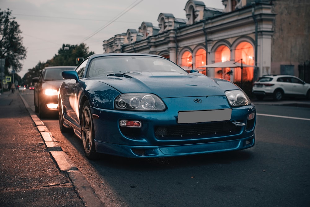 a blue sports car parked on the side of the road